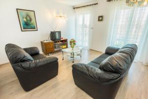 a living room with two leather couches and a tv at Apartments with a parking space Smrika, Kraljevica - 5508 in Šmrika