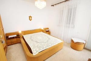a bedroom with a bed and a chandelier at Apartments with a parking space Smrika, Kraljevica - 5508 in Šmrika