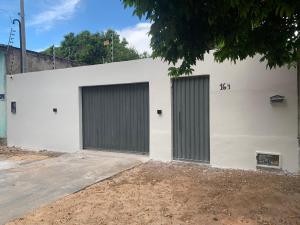un edificio blanco con dos puertas de garaje. en Doce lar BV en Boa Vista