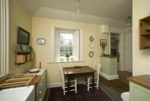 a kitchen and dining room with a table and a window at Salterbridge Gatelodge in Cappoquin