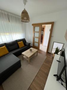 un soggiorno con divano nero e tavolo di Apartamento Bouzavella Panxón a Nigrán