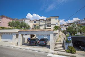 two cars parked in a garage in front of a house at Apartments by the sea Selce, Crikvenica - 5367 in Selce