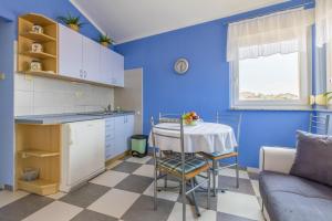 a kitchen with blue walls and a table and a couch at Apartments by the sea Selce, Crikvenica - 5367 in Selce