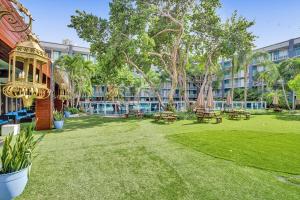 um parque com mesas de piquenique e bancos em frente a um edifício em Fort Lauderdale Grand Hotel em Fort Lauderdale