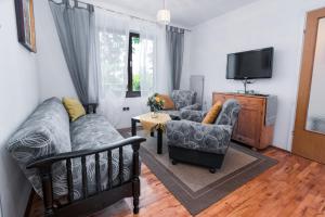 a living room with a couch and chairs and a tv at Apartment Punat 5351a in Punat