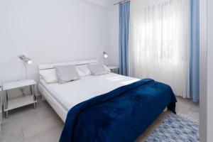 Apartments by the sea Punat, Krk - 5351 في بونات: غرفة نوم عليها سرير وبطانية زرقاء