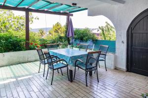 a blue table and chairs on a patio at Apartments by the sea Punat, Krk - 5351 in Punat