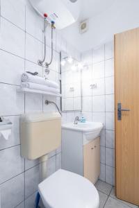 a white bathroom with a toilet and a sink at Apartment Punat 5351b in Punat