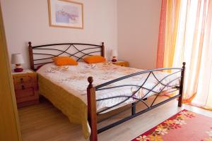 a bedroom with a bed with orange pillows on it at Apartments with a parking space Vrbnik, Krk - 5392 in Vrbnik