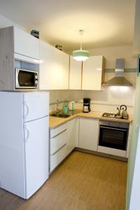 a kitchen with white cabinets and a white refrigerator at Apartments with a parking space Vrbnik, Krk - 5392 in Vrbnik