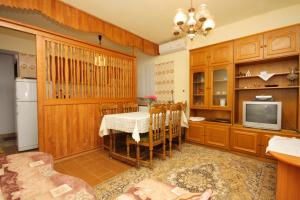 a kitchen with a table and a tv in a room at Apartments with a parking space Punat, Krk - 5350 in Punat