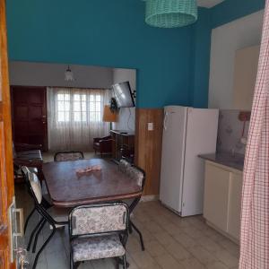 kuchnia i jadalnia ze stołem i lodówką w obiekcie Casa sur FARO w mieście Mar del Plata