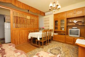 a kitchen with a table and a tv in a room at Apartment Punat 5350b in Punat