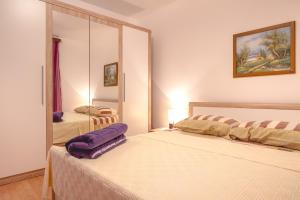 - une chambre avec 2 lits et un miroir dans l'établissement Apartment Njivice 5362b, à Njivice