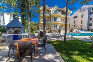 un patio con mesa y sillas y un edificio en Apartments with a swimming pool Jadranovo, Crikvenica - 5521 en Jadranovo