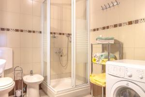 a bathroom with a shower and a washing machine at Apartments and rooms with WiFi Njivice, Krk - 5362 in Njivice