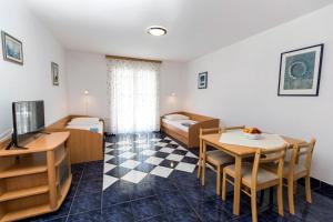 Habitación pequeña con mesa de comedor y dormitorio. en Apartments with a swimming pool Jadranovo, Crikvenica - 5521 en Jadranovo