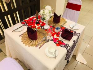 a table with a white table cloth and flowers on it at Hotel Yt Midtown Kuala Terengganu in Kuala Terengganu