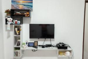 a flat screen tv sitting on a white shelf at The Homestay 105 - nearby sky mirror jetty - Netflix & xbox in Kuala Selangor