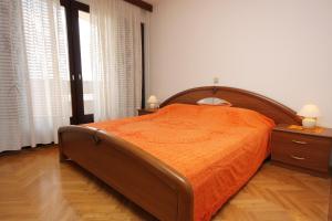 - une chambre avec un grand lit et un couvre-lit orange dans l'établissement Apartments with a parking space Punat, Krk - 5375, à Punat