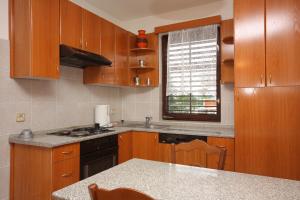 - une cuisine avec des placards en bois et un comptoir dans l'établissement Apartments with a parking space Punat, Krk - 5375, à Punat