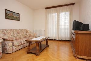 - un salon avec un canapé, une télévision et une table dans l'établissement Apartments with a parking space Punat, Krk - 5375, à Punat