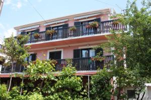 an apartment building with a balcony with potted plants at Double Room Punat 5363c in Punat