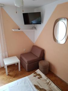 salon z kanapą i telewizorem na ścianie w obiekcie Double Room Punat 5363c w mieście Punat