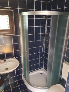 a blue tiled bathroom with a shower and a sink at Double Room Punat 5363c in Punat