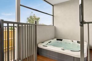 a hot tub on a balcony with a large window at The Manor in Cowes +20 photos