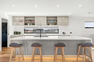 a kitchen with two stools and a white counter top at The Manor in Cowes