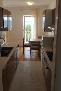 a kitchen with a sink and a table with a window at Apartments with a parking space Selce, Crikvenica - 5475 in Selce