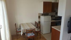 kuchnia ze stołem i krzesłami oraz białą lodówką w obiekcie Apartments with a parking space Selce, Crikvenica - 5475 w mieście Selce