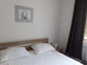 a white bed with two pillows in a bedroom at Apartments with WiFi Selce, Crikvenica - 5498 in Selce