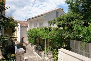 a house with a fence and trees in front of it at Apartments with WiFi Selce, Crikvenica - 5498 in Selce