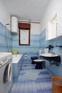 a blue bathroom with a sink and a washing machine at Apartments with parking space Dramalj, Crikvenica - 5491 in Dramalj