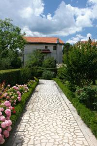 a stone path in front of a house with flowers at Apartments with a parking space Selce, Crikvenica - 5513 in Selce
