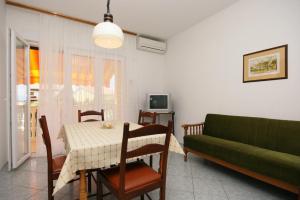 a living room with a table and a green couch at Apartments with a parking space Selce, Crikvenica - 5513 in Selce