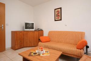 a living room with a couch and a tv on a cabinet at Apartment Pinezici 5464c in Pinezici