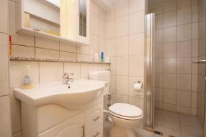 a white bathroom with a sink and a toilet at Apartments with parking space Pinezici, Krk - 5464 in Pinezici
