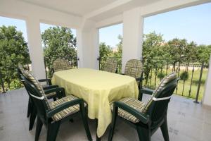 a table and chairs on a screened porch at Apartments with parking space Pinezici, Krk - 5464 in Pinezici +37 photos