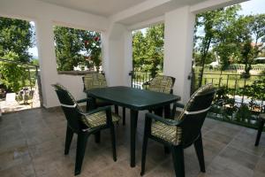a green table and chairs on a porch at Apartments with parking space Pinezici, Krk - 5464 in Pinezici