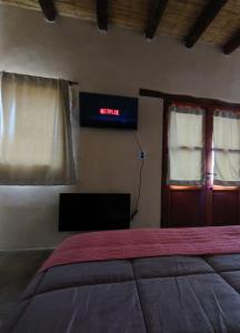 1 dormitorio con 1 cama y un cartel en la pared en Balconcito de Colores en Maimará