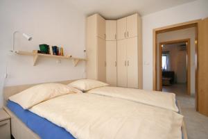 a bed with white sheets and pillows in a room at Apartment Pinezici 5464d in Pinezici