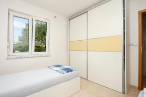 a bedroom with a bed and a window at Apartment Pinezici 5464b in Pinezici