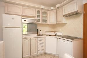 a kitchen with white cabinets and a white refrigerator at Apartment Pinezici 5464b in Pinezici