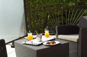 una mesa con dos bebidas y un plato de comida en The Originals City, Hôtel Les Bastides du Gapeau en Solliès-Toucas