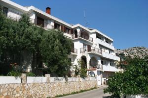 a white building with balconies on the side of a road at Apartments and rooms with parking space Stara Baska, Krk - 5447 in Stara Baška