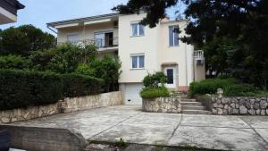 a large white house with a stone wall at Apartments with a parking space Smrika, Kraljevica - 5338 in Šmrika