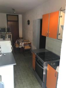 a kitchen with orange cabinets and a stove at Apartments with a parking space Smrika, Kraljevica - 5338 in Šmrika